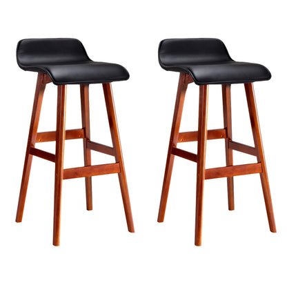 Two black leather bar stools with wooden legs on a white background
