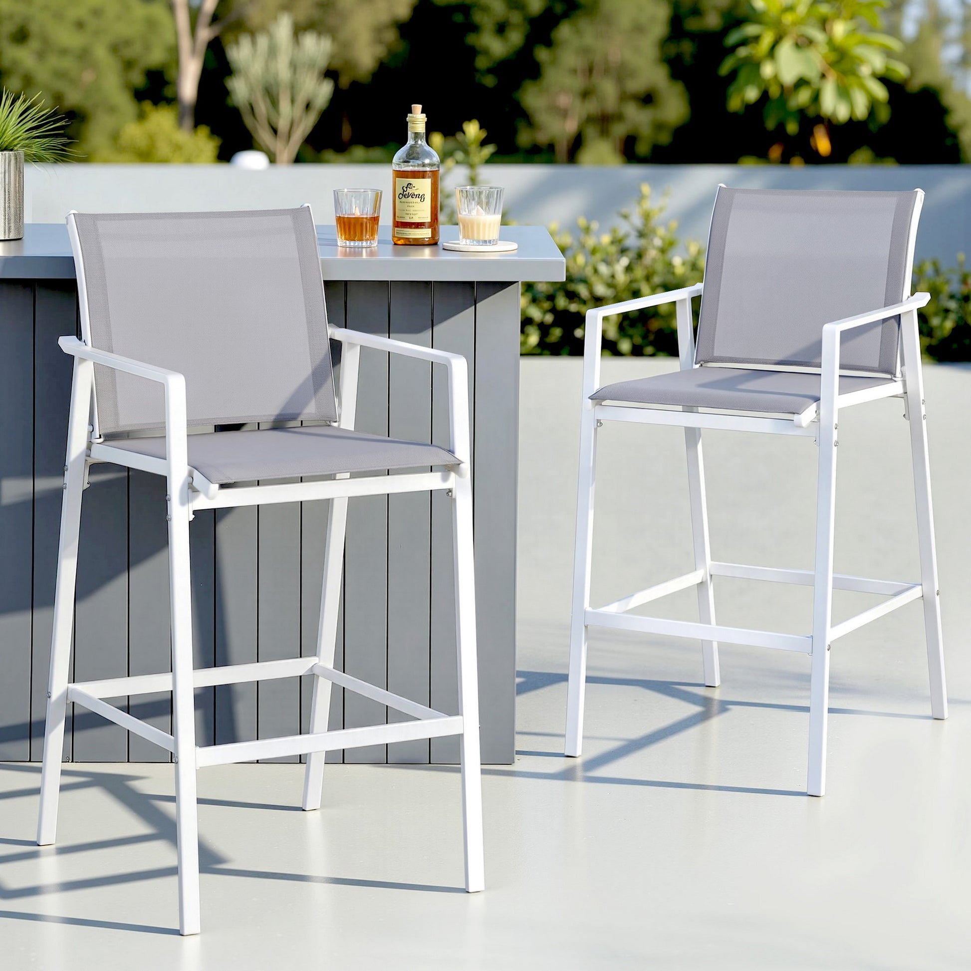 Outdoor setting with two gray high chairs and a small table on a patio.