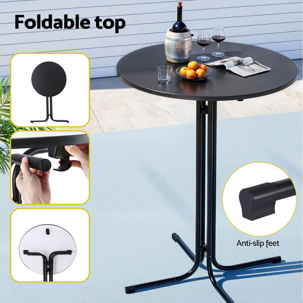 Black foldable table with a bottle of wine, glasses, and fruit on a patio setting.