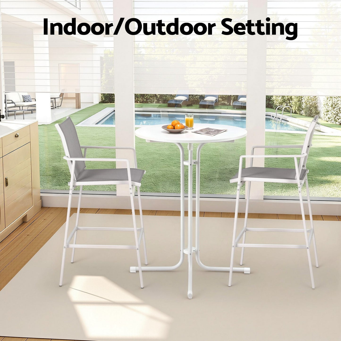 Indoor/outdoor furniture set with table and chairs in a room with a view of a pool.