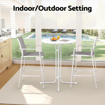 Indoor/outdoor furniture set with table and chairs in a room with a view of a pool.