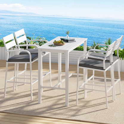 Outdoor dining set with high chairs and table on a deck overlooking the ocean.