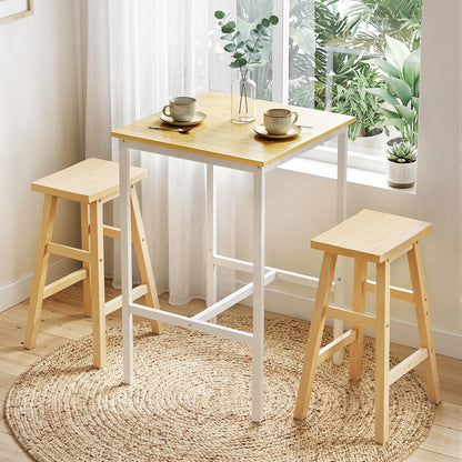 Wooden table with two stools in a bright room with plants