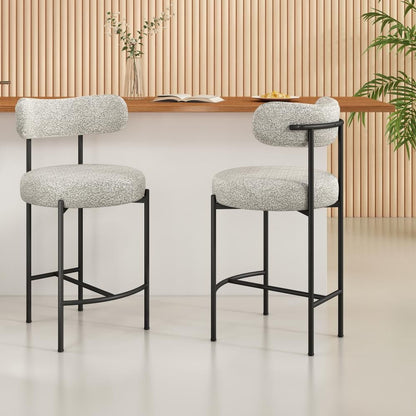 Two white cushioned bar stools with black metal frames in a room with wooden paneling and a plant.