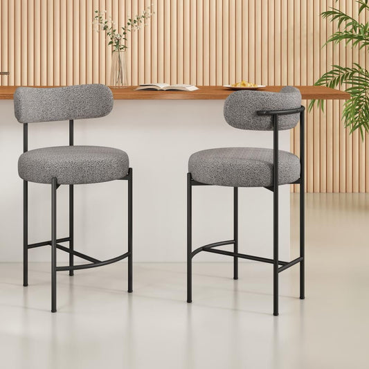 Two gray bar stools with black metal frames in a room with wooden paneling and a plant.