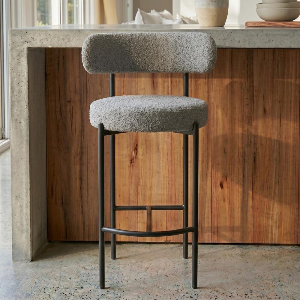 Bar stool with a textured cushioned seat and backrest in a kitchen setting.