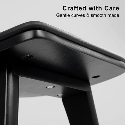 Close-up of a black metal stool with 'Crafted with Care' text on a gray background