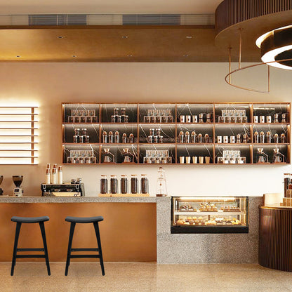 Modern coffee shop interior with shelves, counter, and stools.