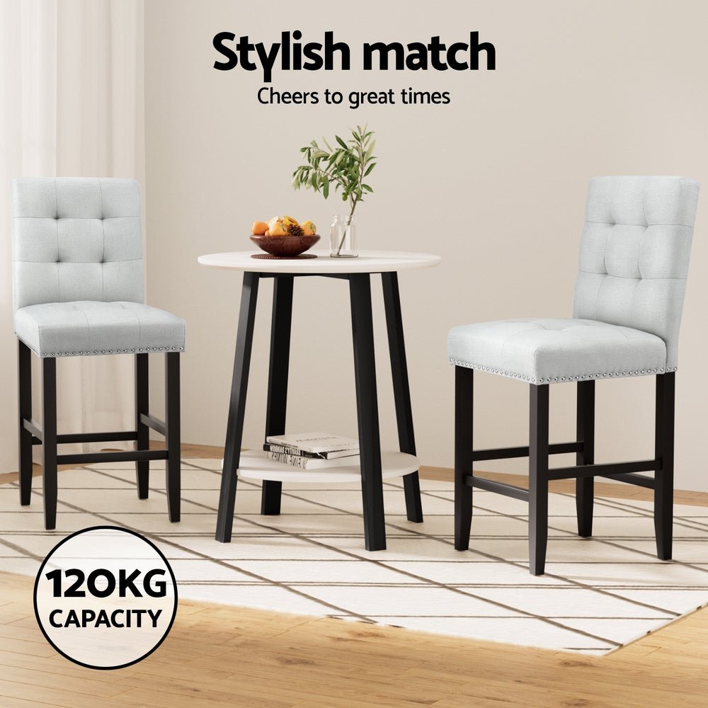 Dining set with two grey bar stools and a small round table on a wooden floor.