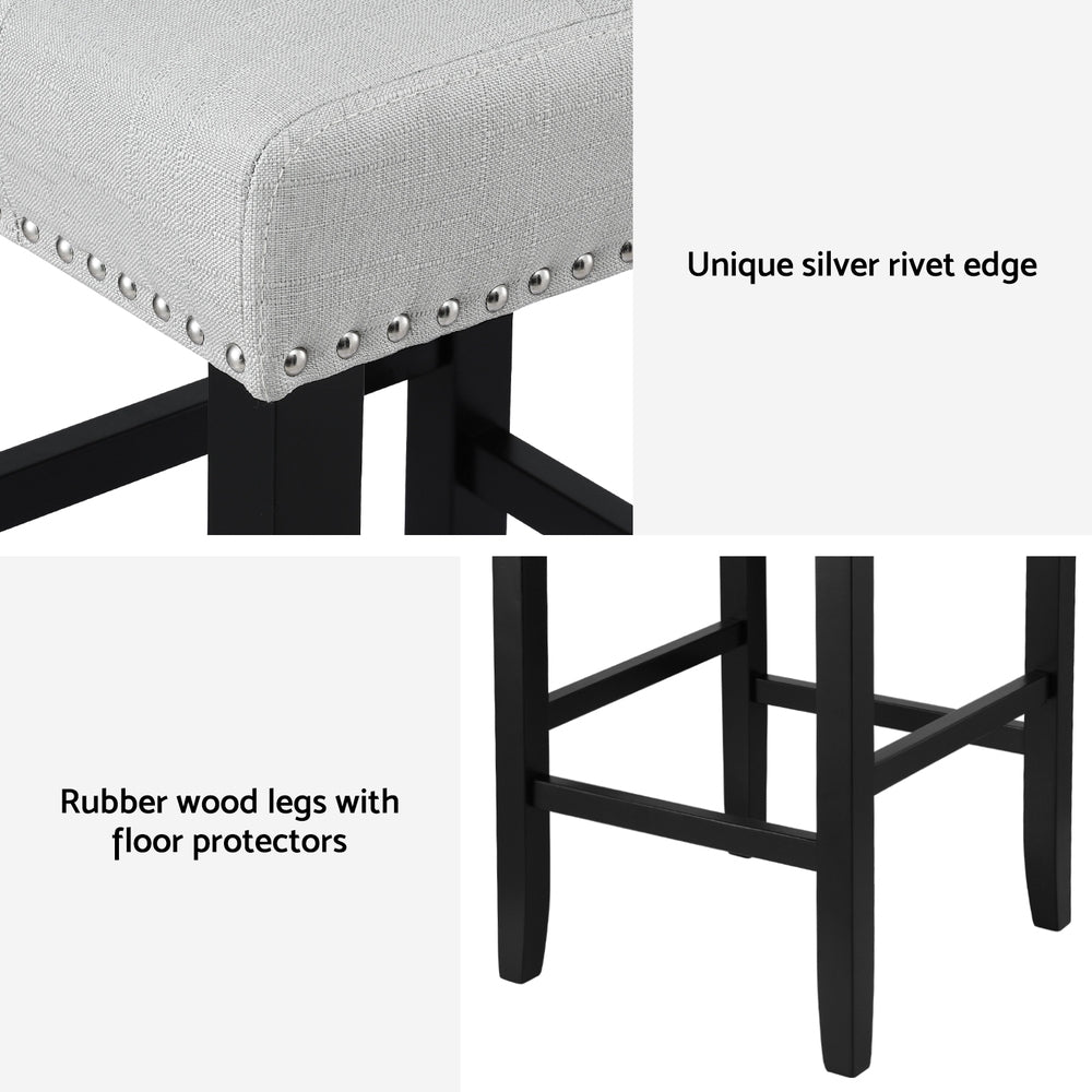 Grey cushioned stool with black legs and silver rivets on a white background