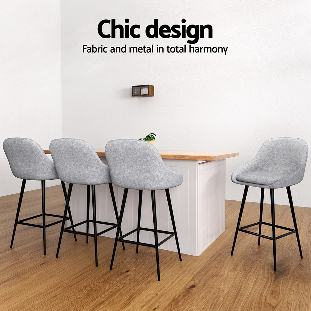 Gray bar stools with black legs around a wooden table in a modern room.