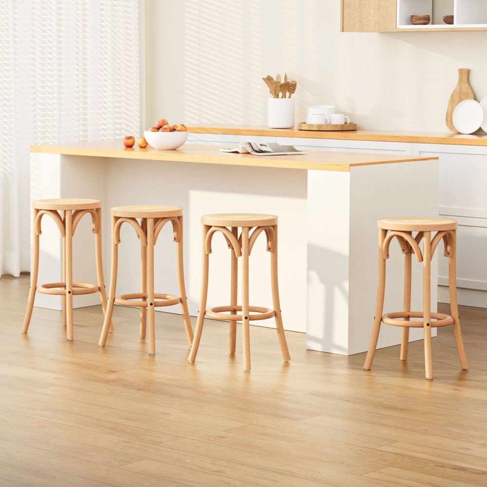 Set of four natural 65cm beechwood bar stools with round rattan seats and footrests in a bright kitchen setting