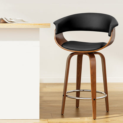 Jasper black PU leather swivel bar stool with walnut-finish timber frame at a kitchen island