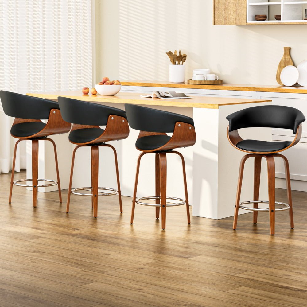 Set of 4 Jasper black PU leather swivel bar stools with walnut-finish timber frames at a kitchen island