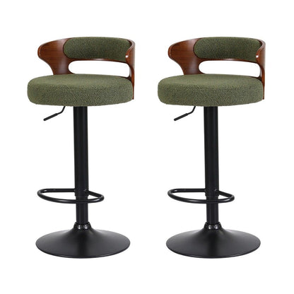 Set of 2 Juna green bouclé adjustable swivel bar stools with curved walnut-look backrests and black pedestal bases on a white background.