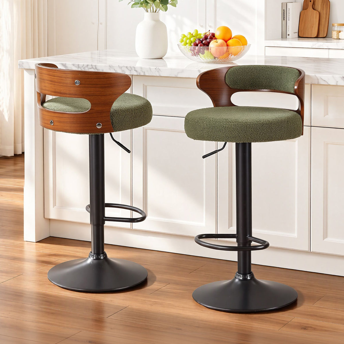 Two Juna green bouclé swivel bar stools with walnut-look backrests positioned beside a white marble kitchen island.