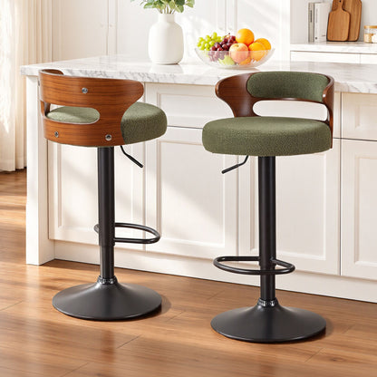 Two Juna green bouclé swivel bar stools with walnut-look backrests positioned beside a white marble kitchen island.