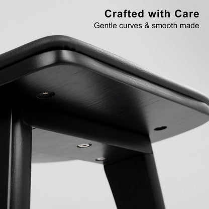 Close-up of a black metal stool with 'Crafted with Care' text on a gray background