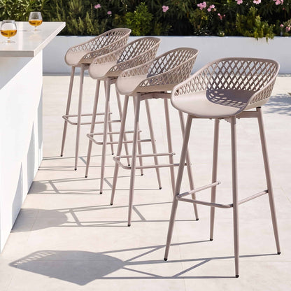 Four beige Kian outdoor bar stools beside a white outdoor bar counter.