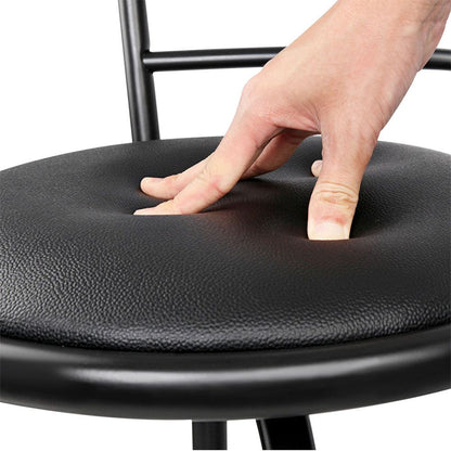 Hand pressing down on a black chair seat cushion to demonstrate its softness.
