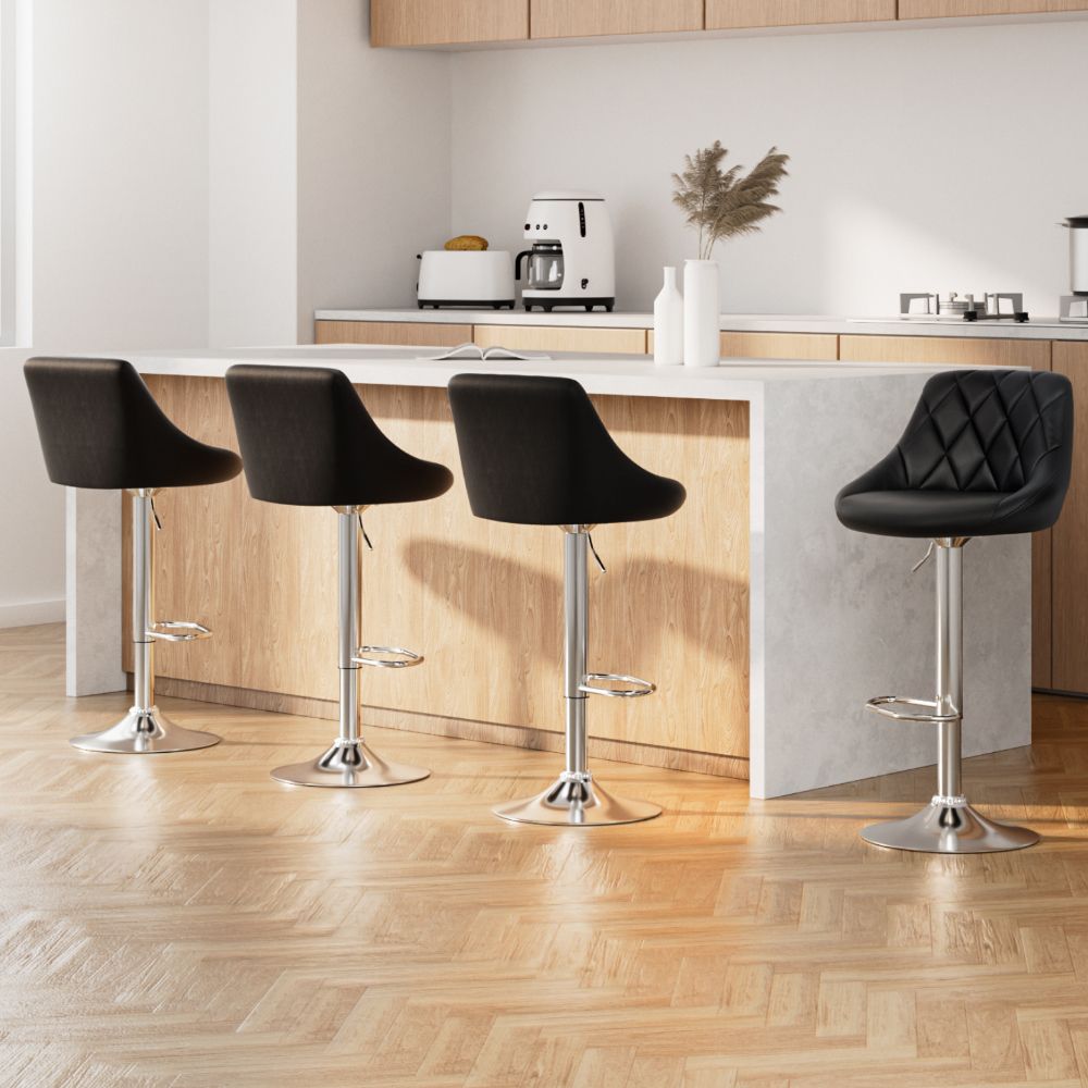 Modern kitchen with black bar stools and a white countertop.