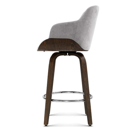 Side profile of the grey Remi 70cm velvet swivel bar stool with timber legs and chrome footrests