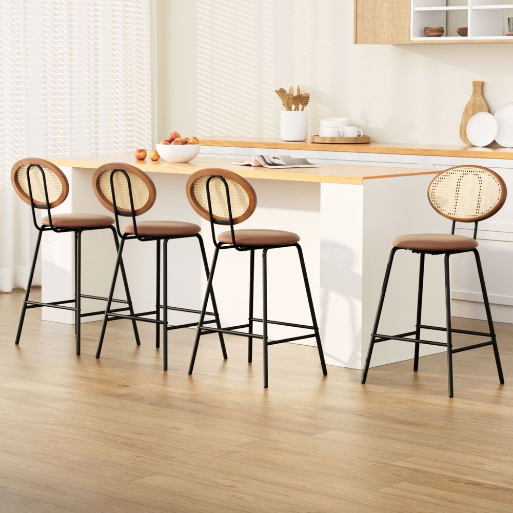 Four bar stools with brown leather seats and black legs in a kitchen setting.