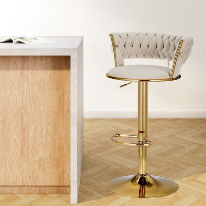 Single Sola adjustable velvet swivel bar stool in ivory with tufted back, gold-toned pedestal base and footrest. Shown in a bright kitchen setting.