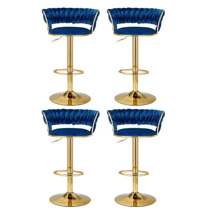 Four Sola adjustable velvet swivel bar stools in navy blue with tufted backs, gold-toned pedestal bases and footrests.