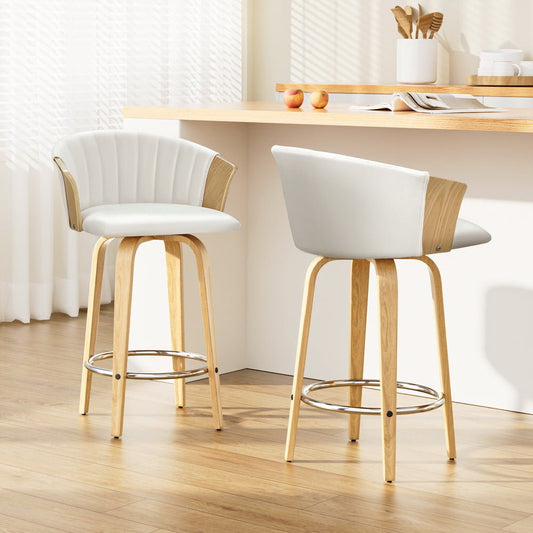 Two white bar stools with wooden legs in a kitchen setting.