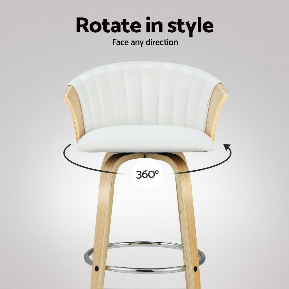 A swivel bar stool with a white padded seat and curved backrest, light wood arms and legs, and a chrome footrest. Text at the top reads 'Rotate in style' with 'Face any direction' and a circular arrow indicating a 360-degree rotation.