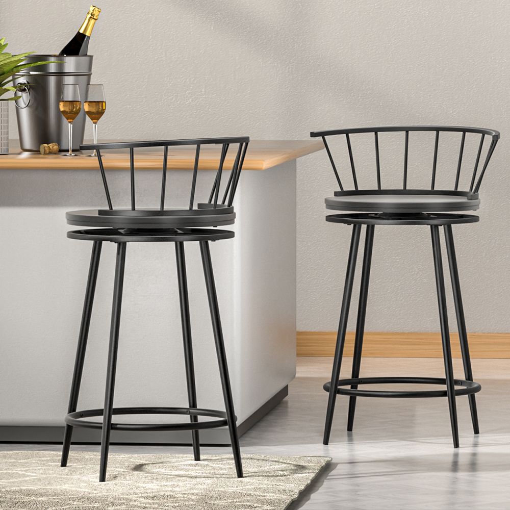 Two black metal bar stools in a modern kitchen setting with a neutral color scheme.