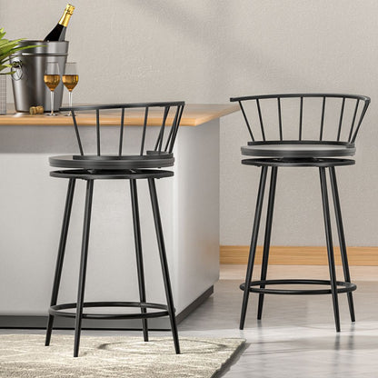 Two black metal bar stools in a modern kitchen setting with a neutral color scheme.