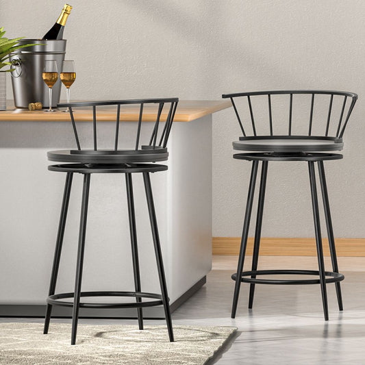 Two black metal bar stools in a modern kitchen setting with a neutral color scheme.
